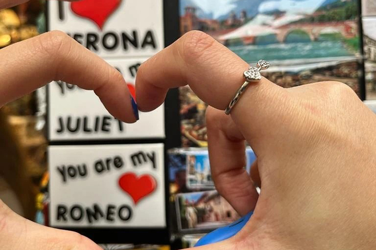 Formar hjärta med fingrar framför skylt You are my Romeo
