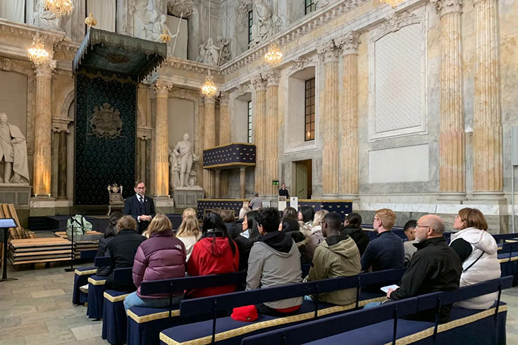 Ungdomar sitter framför silvertronen i stockholms slott